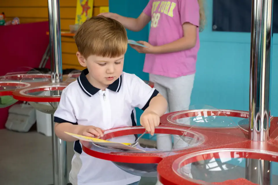 Young boy anjoying the sand art activity at Lyons Robin Hood' adventure den