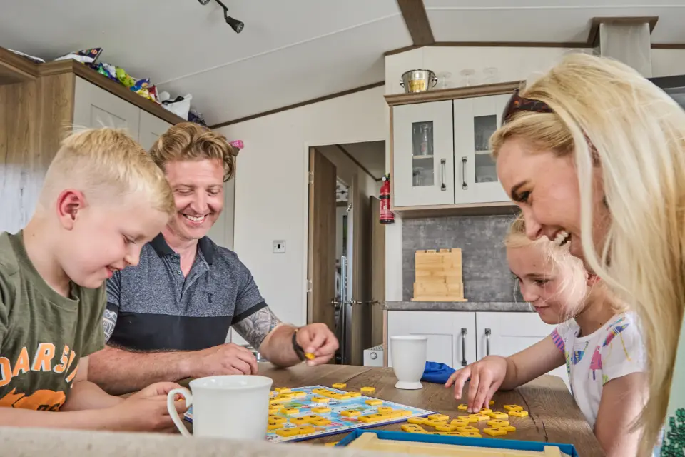 Family playing board games whilst on their caravan holiday in North Wales