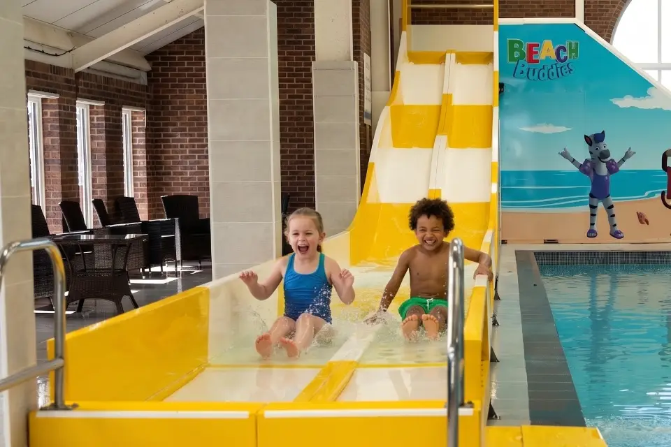 Children coming down the splash zone slide at lyons robin hood in rhyl enjoyign their caravan holiday which is action packed