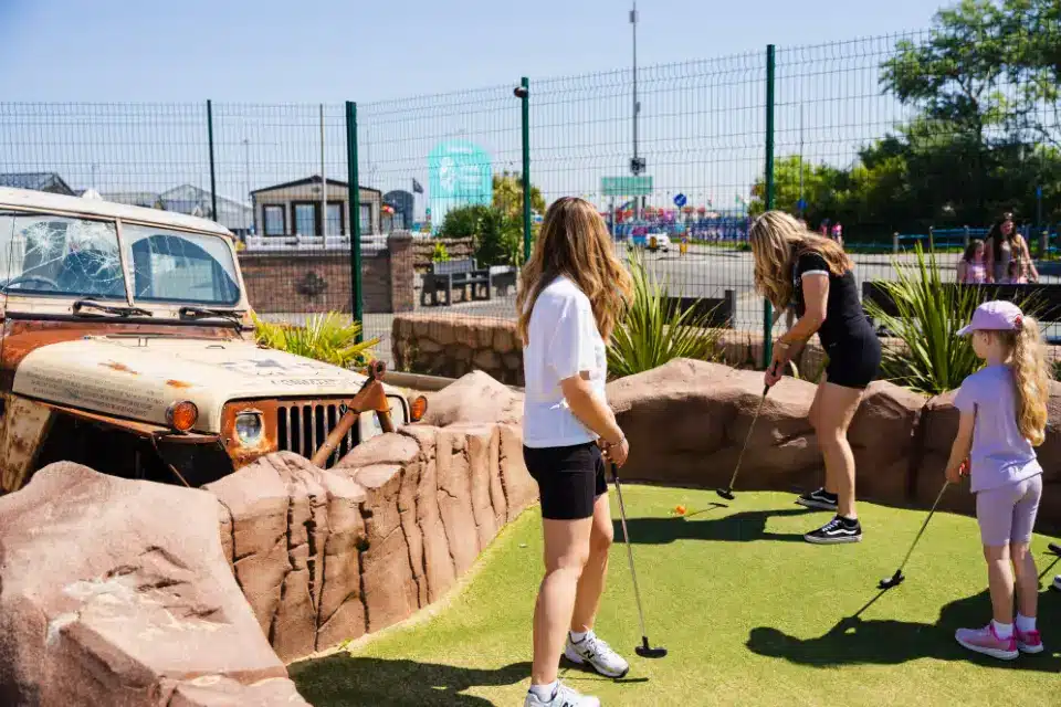 2 girls playing hole 4 of safari adventure golf in Towyn, North Wales